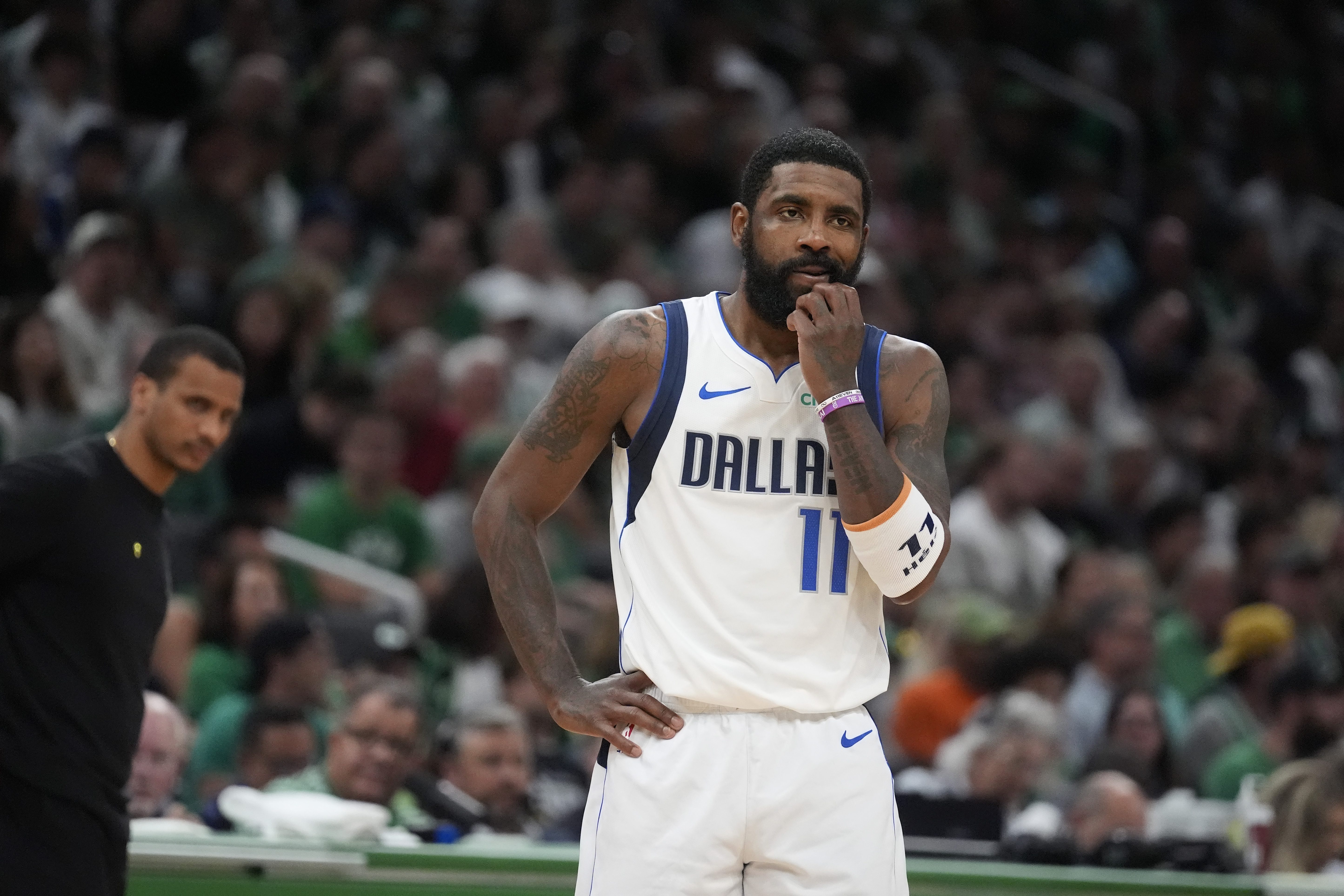 FILE - Dallas Mavericks guard Kyrie Irving pauses on the court in front of Boston Celtics head coach Joe Mazzulla, left, during the first half of Game 5 of the NBA basketball finals, June 17, 2024, in Boston. Irving has a broken left hand that required surgery after getting injured in an offseason workout. The Dallas Mavericks aren't providing a timeline for Irving's recovery. (AP Photo/Charles Krupa, File)