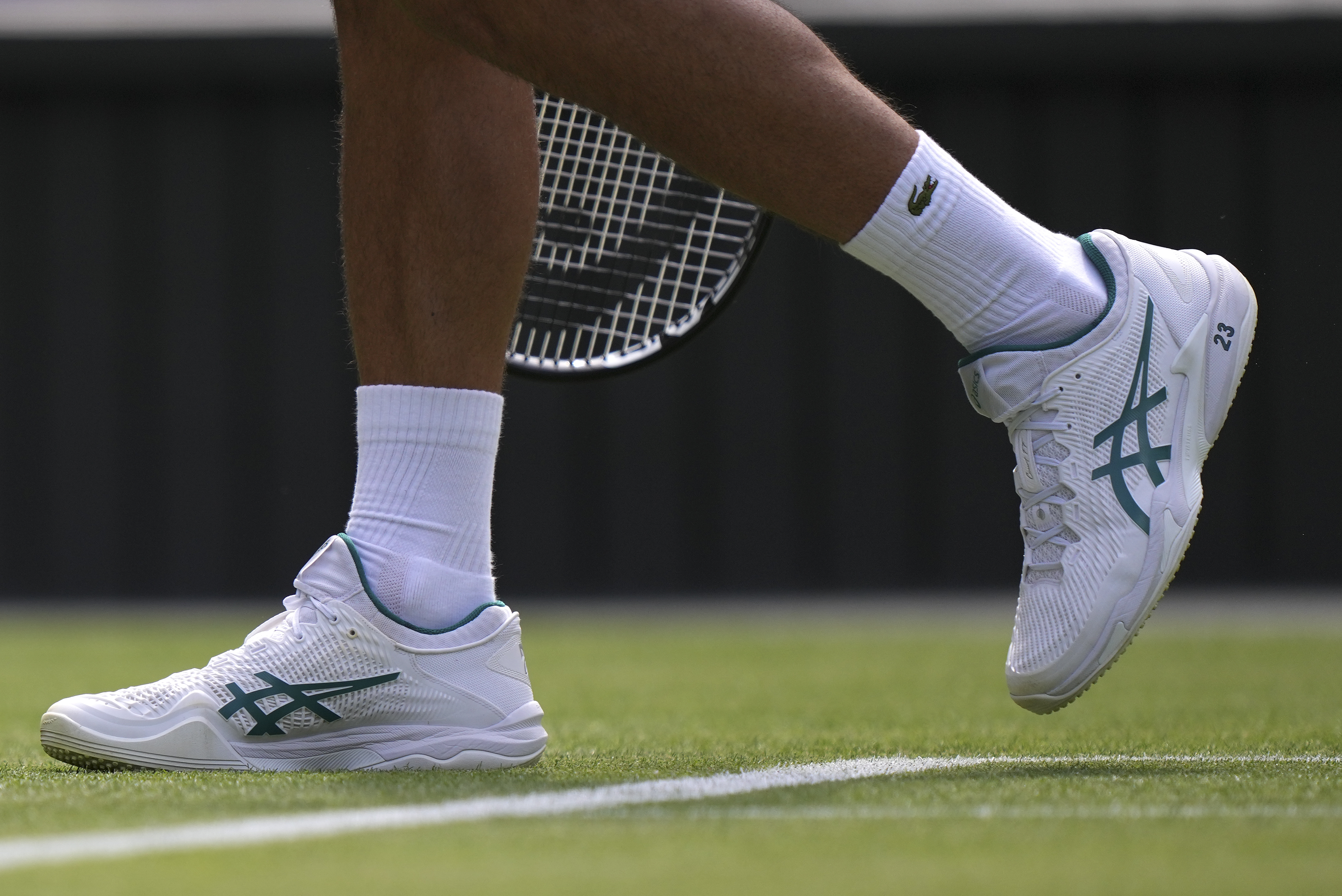 Novak Djokovic plays at Wimbledon with the number '23' printed on his white  tennis shoes